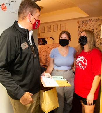 SIUE Vice Chancellor for Student Affairs Jeffrey Waple greets first-year students (L-R) Emily Balla, of Arlington Heights, and Ally Schuneman, of Bloomington, during the House Calls event.