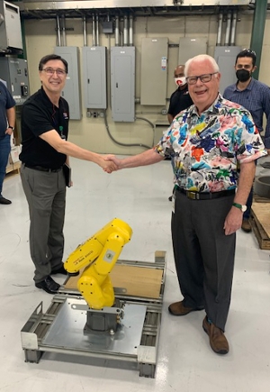 SIUE School of Engineering Dean Cem Karacal and H-J Family of Companies founder and owner Jim Shekelton shake hands to acknowledge the mutually beneficial donation of a new, state-of-the-art robotic arm.