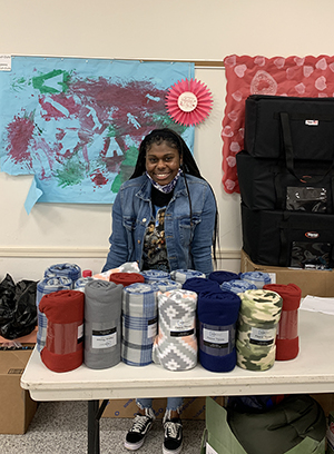 CAS biological sciences senior and SIUE Rotary Student Leader of the Month Taylor Ewing with a collection of blankets she donated to PotBangerz.