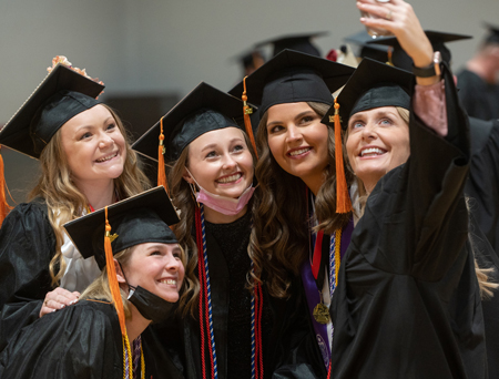 A group of nursing graduates gathers for a selfie.