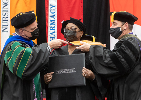 A graduate is hooded during the School of Nursing ceremony.