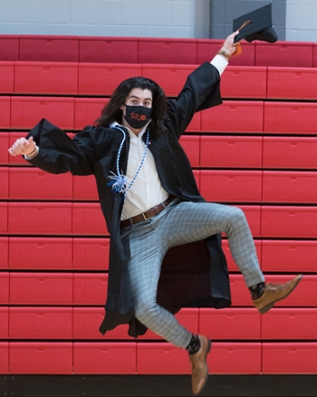 Graduate jumps in celebration ahead of commencement ceremony.