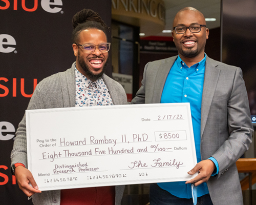 ck Faculty and Staff Association President J.T. Snipes, PhD, assistant professor in the Department of Educational Leadership, presents a check to Distinguished Research Professor Howard Rambsy, II, PhD. Colleagues and students, past and present, gene