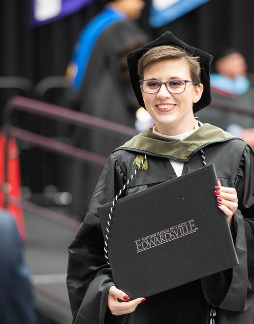 A SOP graduate holds their diploma during the spring 2022 commencement ceremony.