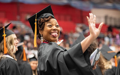 A School of Nursing graduate saves to her support system in celebration.