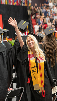An SIUE graduate waves to family and friends.
