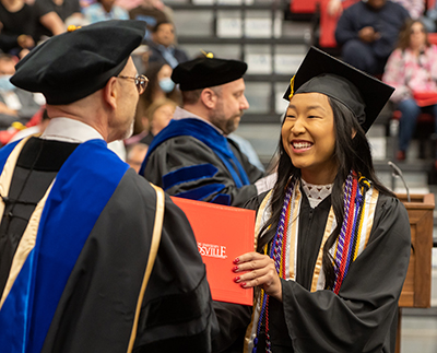 An SIUE graduate receives her diploma during the spring 2022 commencement ceremonies.