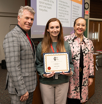 Second-year SIU SDM student Kaitlyn Stanton (center) took first place in the Research Day Student Table Clinic Competition. She stands with SIU SDM Interim Dean Duane Douglas, DMD, and SIU SDM Interim Director of Research Nathalia Garcia, DDS, MS.