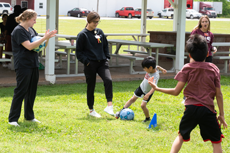 SIUE community health nursing students play soccer with Fairmont City Library’s summer program attendees.