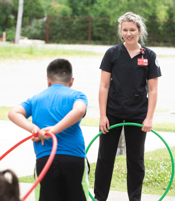 SIUE nursing student hula-hoops with summer program attendee. 