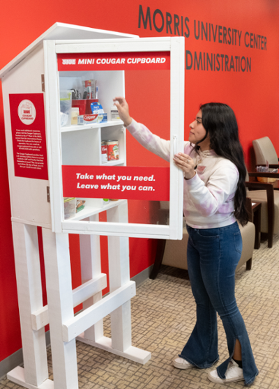 Student worker Ingrid Galeana helps load a Mini Cougar Cupboard in the Morris University Center