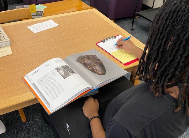 Student sketching photo in book
