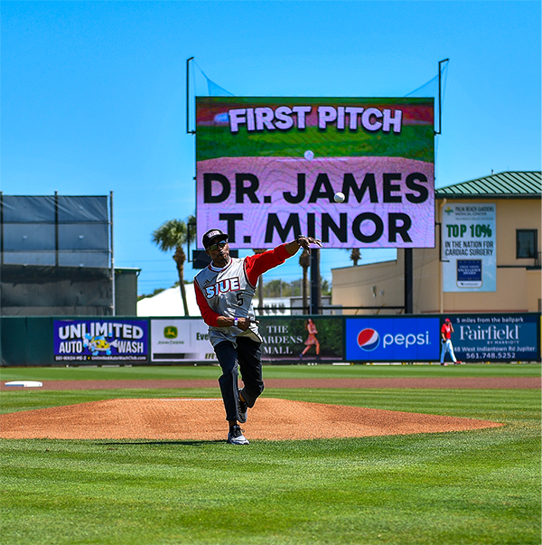 Chancellor Dr James T Minor is at pitching mound throwing the first pitch to a catcher