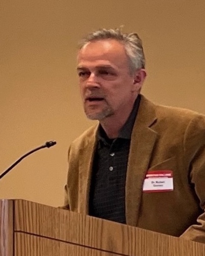 Gomez speaking at podium