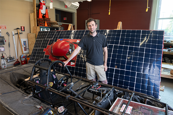 Student Jakob Schoeberle stands next to SIUE Solar Car
