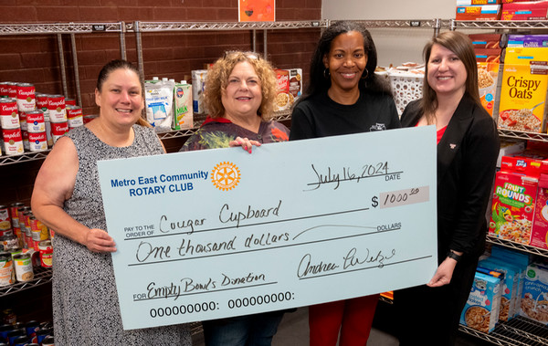 Four SIUE Colleagues who manage the Cougar Cupboard hold a big check for 1000 dollars