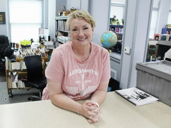 Photo of Angela Custer in the library leaning on the counter