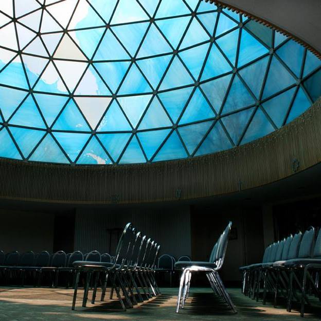 Low angle photograph from inside the Fuller Dome with chairs and ceiling