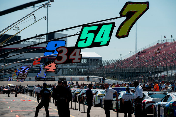 Landscape of Pit Road at World Wide Technology Raceway with crew chiefs and race teams and cars lined up to start the Enjoy Illinois 300