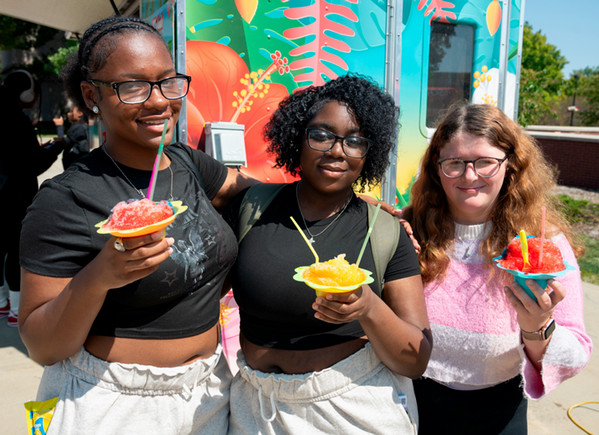 Three students enjoying Hawaiian shave ice on a sunny day in the Quad