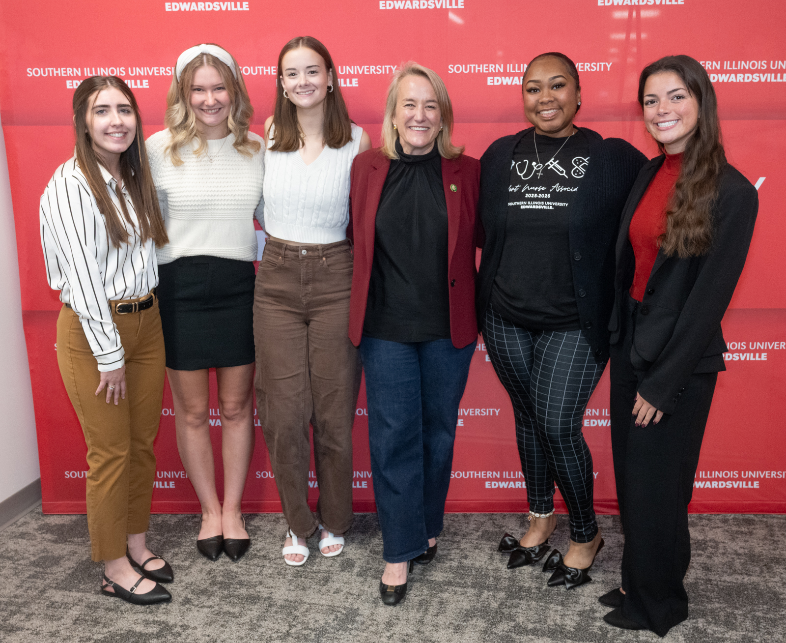  Congresswoman Budzinski posing for a standing photo with five SIUE nursing students