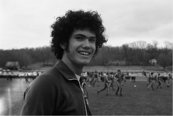 Chris Carenza poses on soccer field in front of team