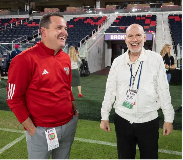 Anderw Gavin and Chis Carenza talking on field and facing the camera