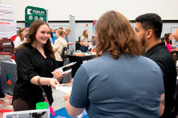 Young woman inquiring at a networking booth