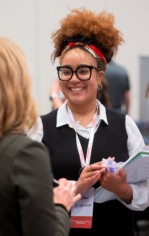 Pharmacy student talks and smiles with recruiter whose face we cannot see