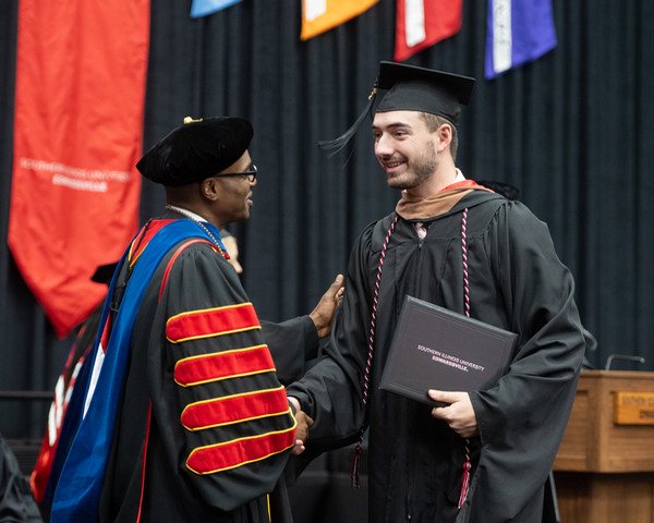 Graduate Dawson Taylor shakes Dr Minors hand on stage