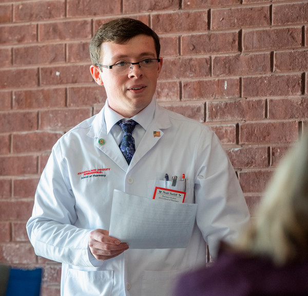 Noah Sutliff in white lab coat at diabetes symposium