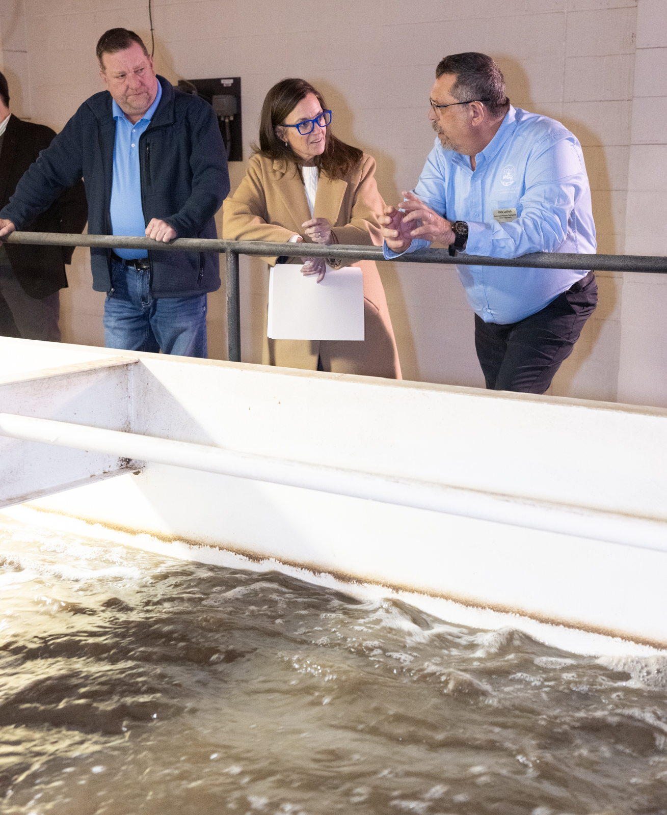 Illinois State Representative Katie Stuart speaks with Environmental Resources Training Center staff while observing an aeration tank during a tour of SIUE’s water and wastewater training facility.