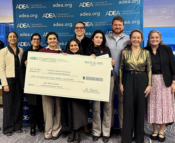 Students holding big $350 check from winning an award