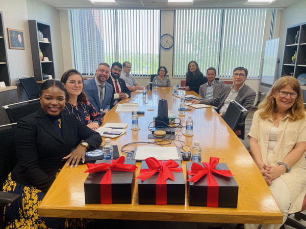 Quebec delegation and SIUE staff seated at conference table posing for camera