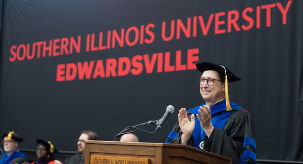 Dean Karacal applauds graduates from the commencement stage