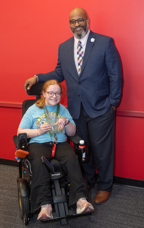 Maddie Proctor and Dominic Dorsey pose in front of red wall