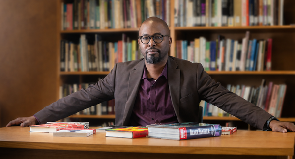Prof Rambsy at desk with books in front of him