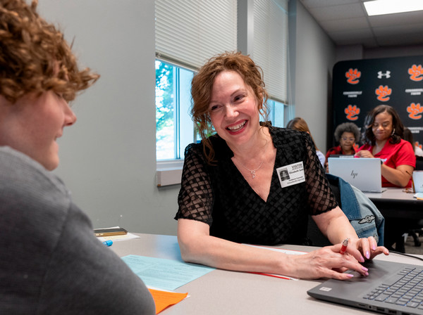 SIUE staff member smiles in conversation with EHS student