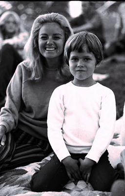 Black and white archival photo of Wilma Jene Bond and daughter Julie at the MRF site. They are sitting on a blanket outside on "the lawn" and smiling.