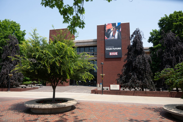 Commencement grad on banner at Lovejoy Library