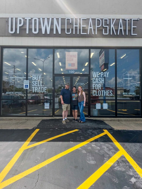 Couple and daughter photographed in front of storefront