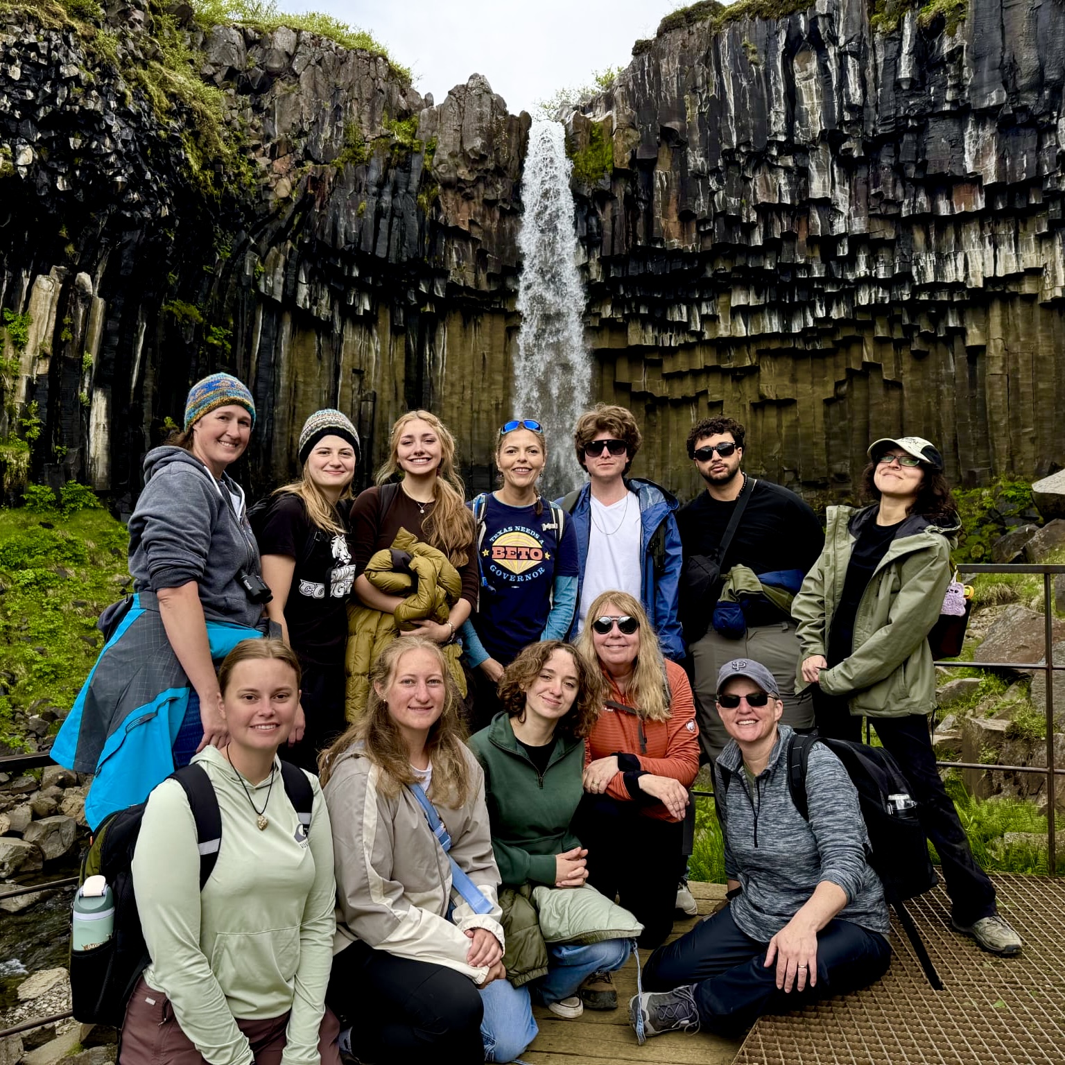 Photo of ten students at SIUE in front of a majestic waterfall on an overcast day