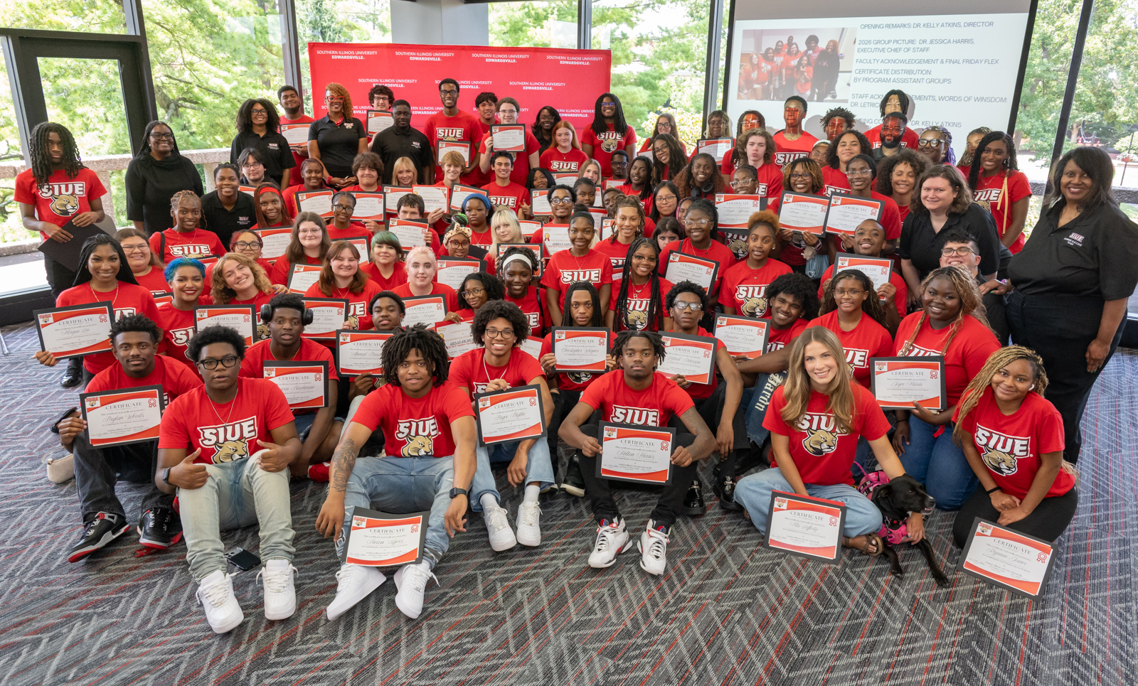 Group shot of students in a MUC conference room holding certificates of completion