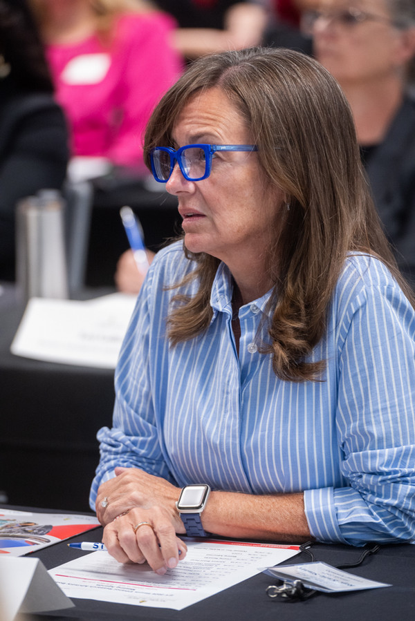 Rep Katie Stuart talking while seated at table at NCERC meeting