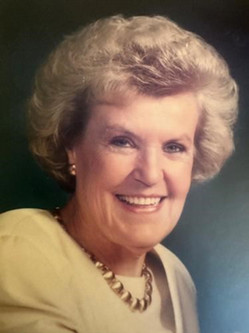 Portrait of McDonald. She has short curled hair, a big smile, and wearing a yellow blouse and gold necklace
