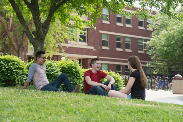 Group of students on the grass in front of a residence hall