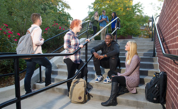 A group of students sitting outside on stairs