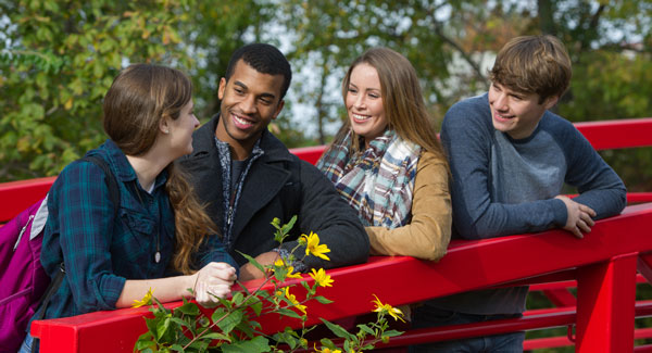 Four students on a red bridge