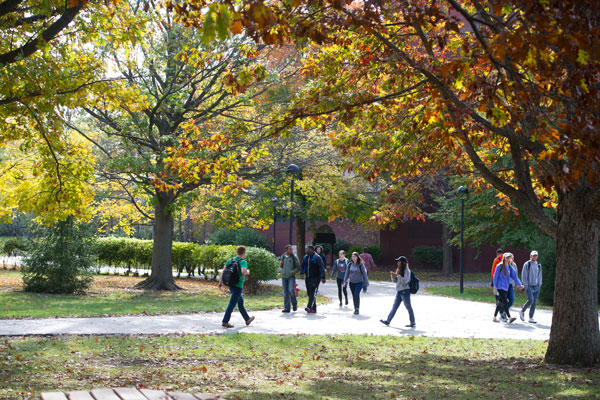 Students walking on campus with fall trees
