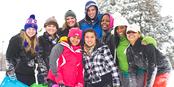 Happy SIUE students huddled together on a snowy day
